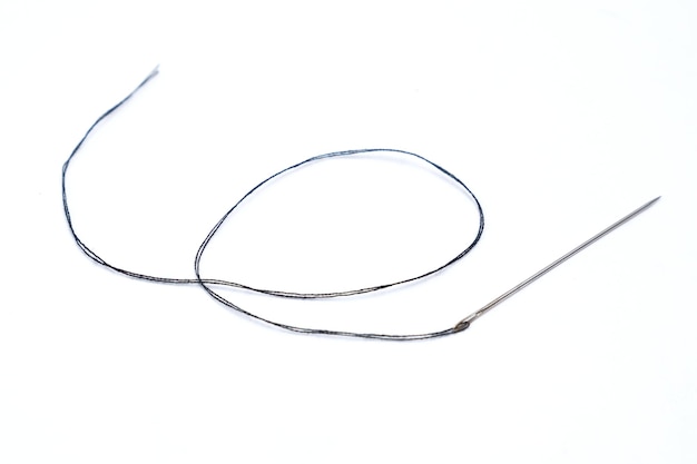 Black thread and needle over white background