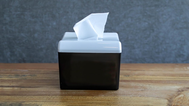 A black tissue box at the wooden table