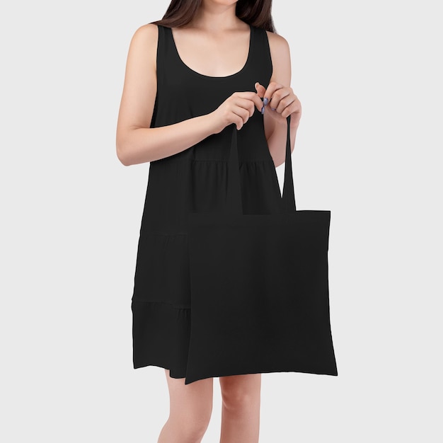 Foto borsa nera sulla mano di una ragazza in una borsa ecologica prendisole per lo shopping al dettaglio per il modello di design
