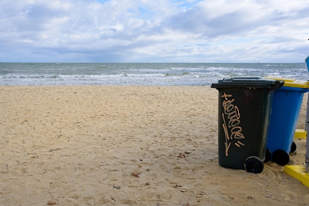 A black trash can with the word " waste " on it