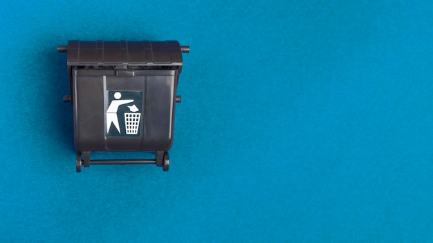 Photo black trash toy can or recycle bin on blue background