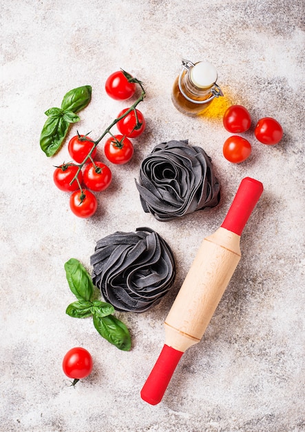 Black uncooked pasta  with tomato and basil