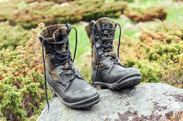 Black used hiking boots on the stone