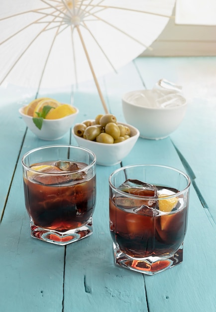 Black vermouth with olives on blue wooden