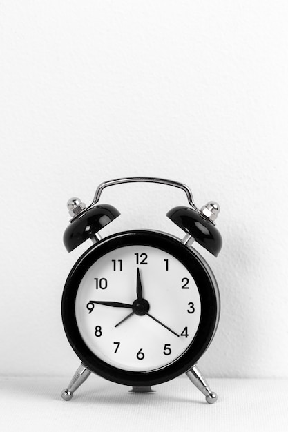 Black vintage alarm clock on white 