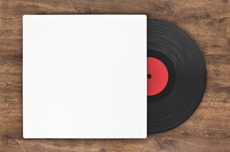Black vinyl record in paper case on wood background