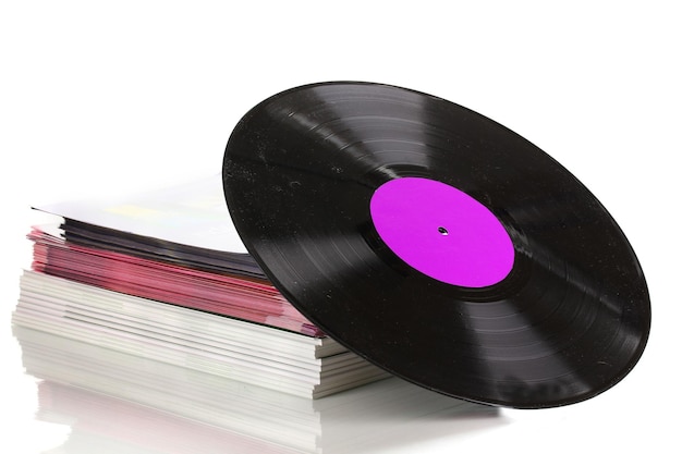 Black vinyl record and stack of magazines isolated on white