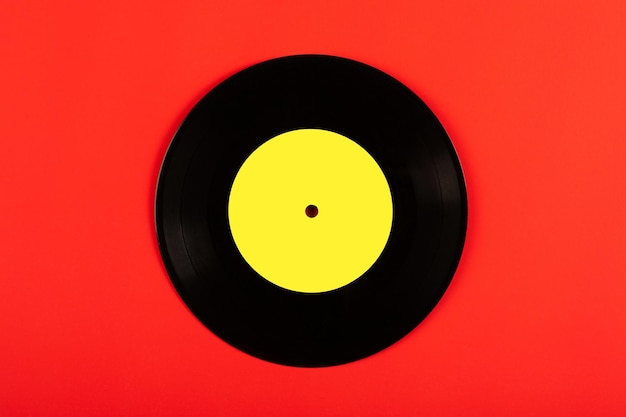 black vinyl record with yellow label on red backgroundtop view