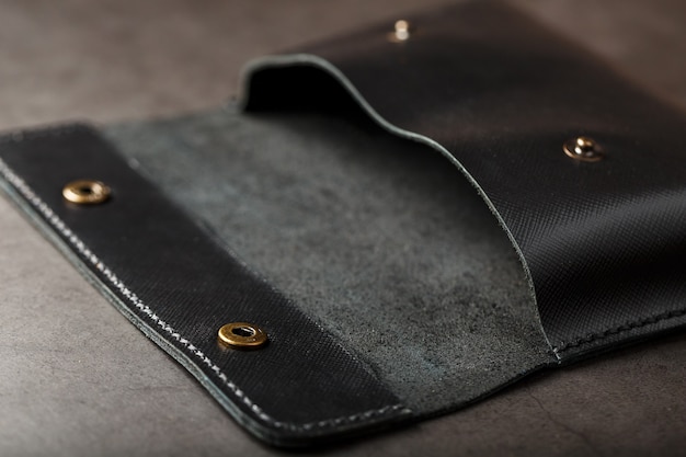 Black wallet made of genuine leather on dark 