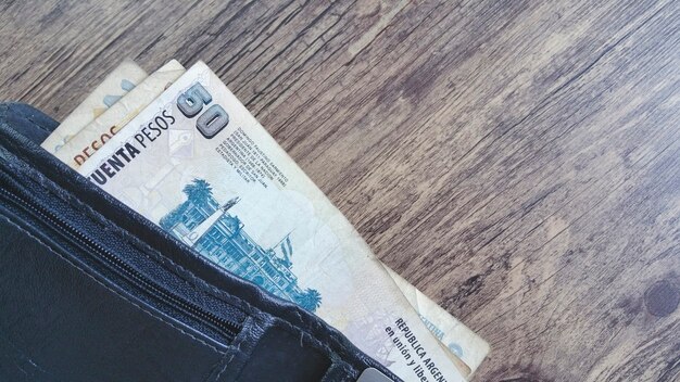 Black wallet with argentinian money and copy space.