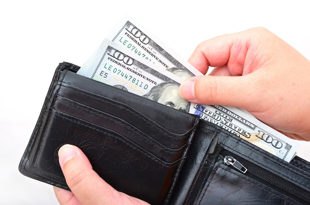 Black wallet with US dollars in the hands on a whitebackground