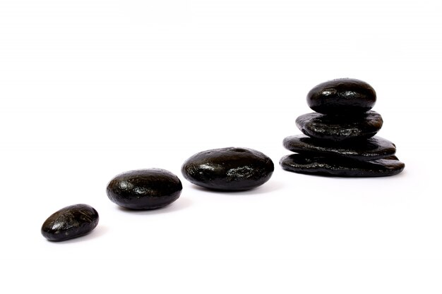 Black wet stones on white wall