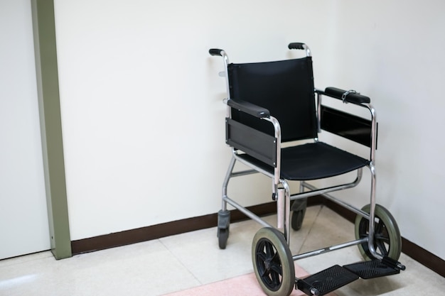 Black wheelchair on hospital floor with white background