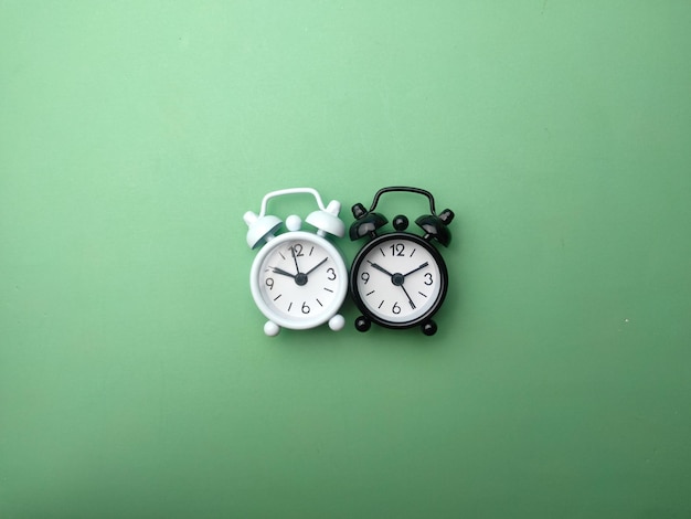 Black and white alarm clock on a green background