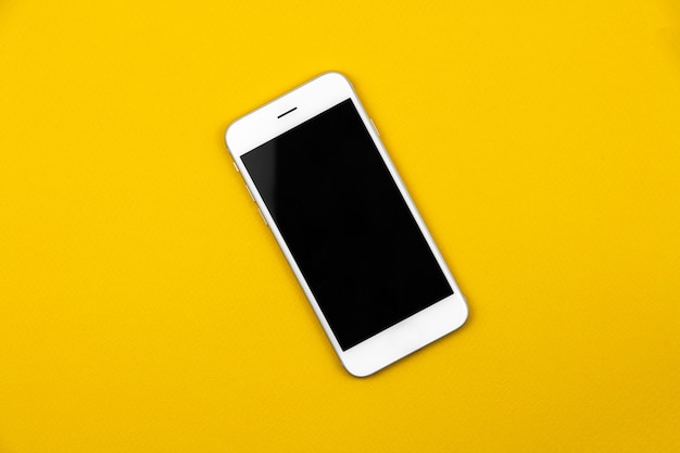 Черный белый пустой смартфон на изолированном желтом фоне, макете и концептуальном дизайне, шаблоне. Фото высокого качества