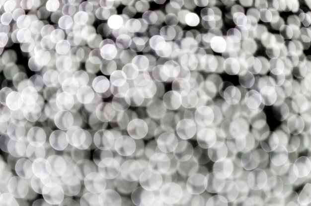 Black and white bokeh abstract background with defocused sparkling lights.