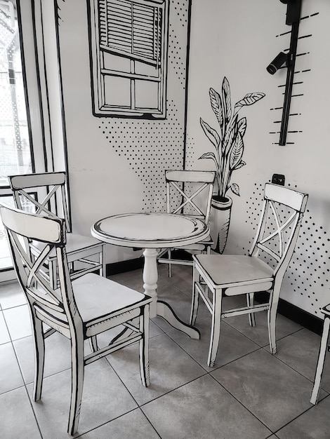 A black and white drawing of a table and chairs in a room with a clock on the wall interior design