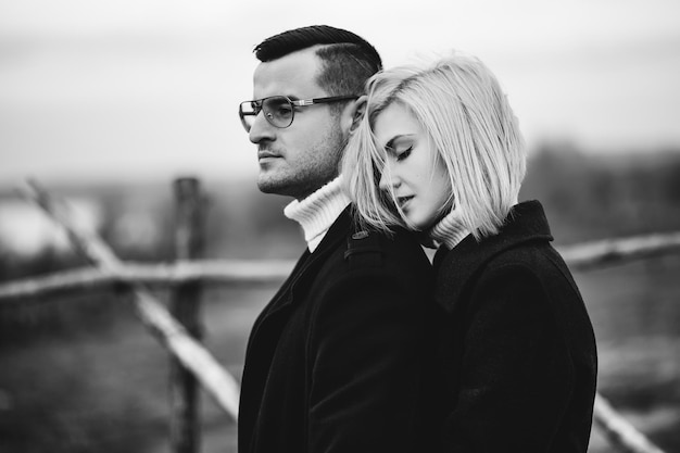 Black-white fashionable portrait of a young couple in love. Stylish autumn love story