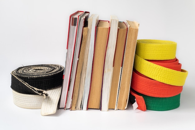 Black and white martial arts belt on a stack of books on the\
study of martial arts of aikido karate judo body and mind\
development