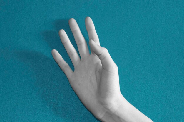 A black and white open hand on a blue background