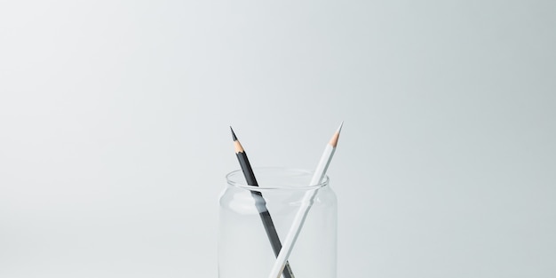 Black and white pencils in a glass jar