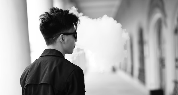 Black White photo of Asian young man outdoors posing at camera