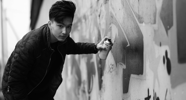 Black White photo of Asian young man outdoors posing at camera