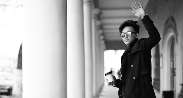 Photo black white photo of asian young man outdoors posing at camera