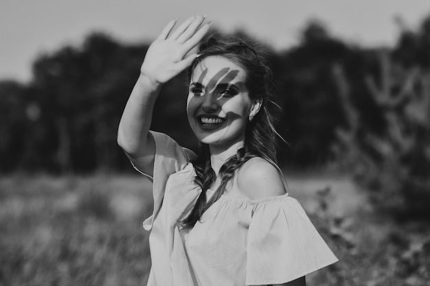 Foto in bianco e nero di una bellissima modella. la donna sorride. emozioni. ombra della mano