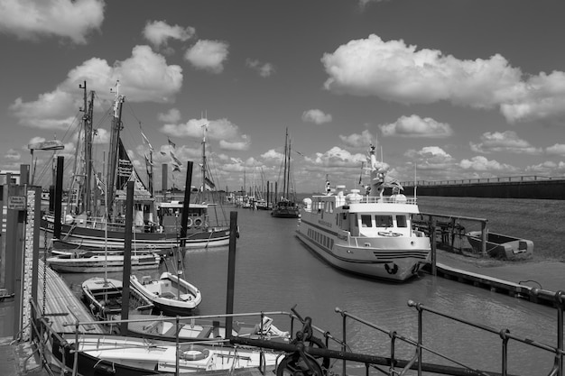 a black and white photo of boats in a harbor with a sky background