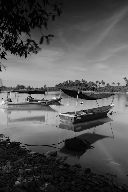 A black and white photo of boats on the water with a black and white photo of a boat in the water.