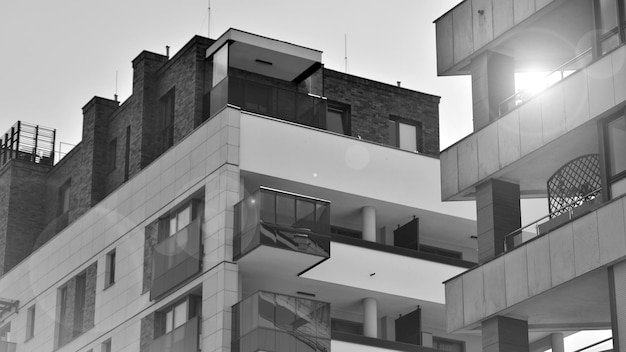 a black and white photo of a building with a balcony and a flag on the top.