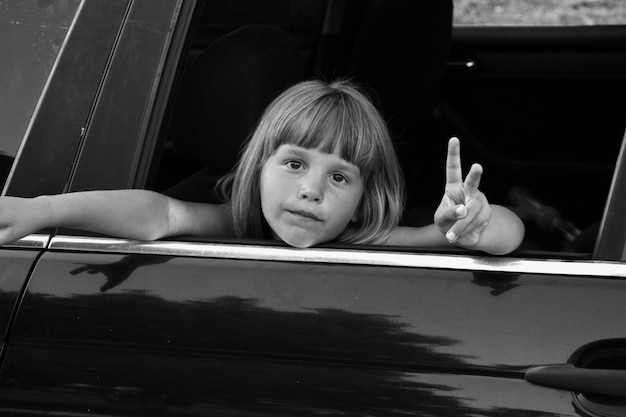 Black and white photo of a child in the car