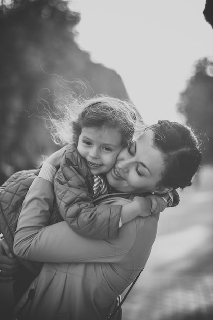 Black and white photo of a girl hugging her mother