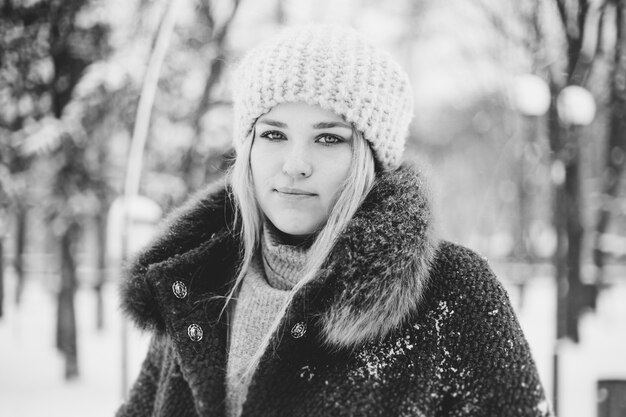 Black and white photo of a girl in a snow covered park