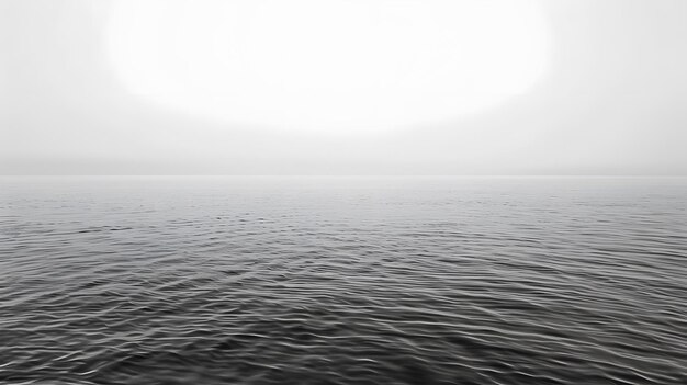 a black and white photo of a lake with a mountain in the background