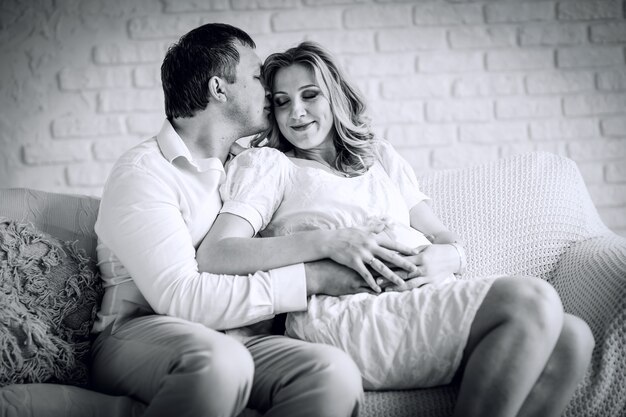 Black and white photo in retro style.portrait of happy husband with his pregnant wife