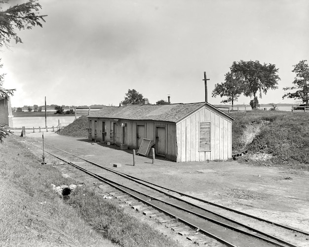 a black and white photo of a small building with a cross on the top