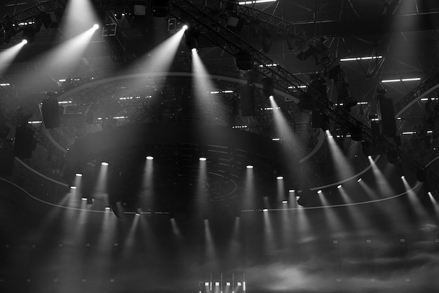 A black and white photo of a stage with lights from the top Moving Head Light beam