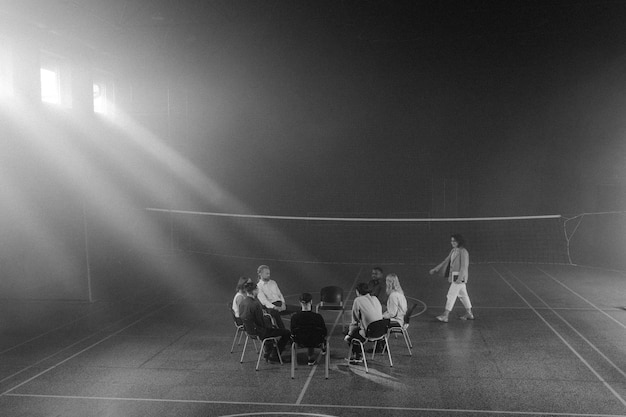 a black and white photo of a tennis game with a net in the middle