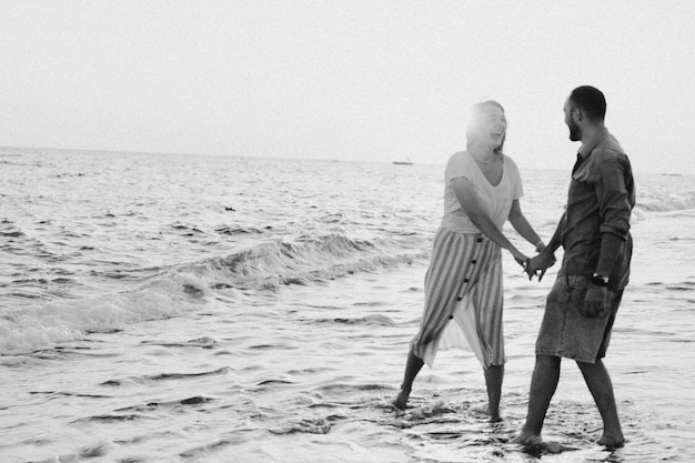 Black and white photo Young romantic couple dancing turning around by sea