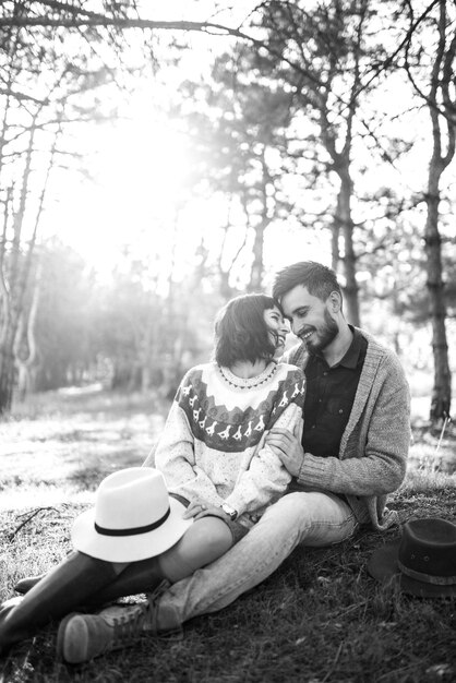 Black and white photos Lovely hipster couple with bike Couple wearing beautiful hats and sweaters