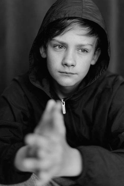 Black and white portrait of teenage boy on dark background Low key close up shot of a young teen boy Black and white photography Selective focus