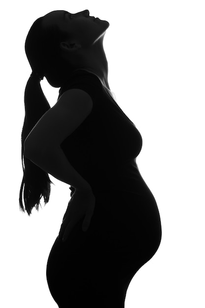 Черно-белый силуэт портрет беременной женщины, наклонив голову на белом фоне, вертикальный