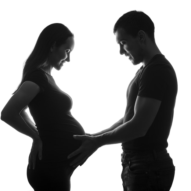 Black and white silhouette portrait pregnant woman and man, long-awaited happy pregnancy, family concept, silhouette couple, ivf pregnancy