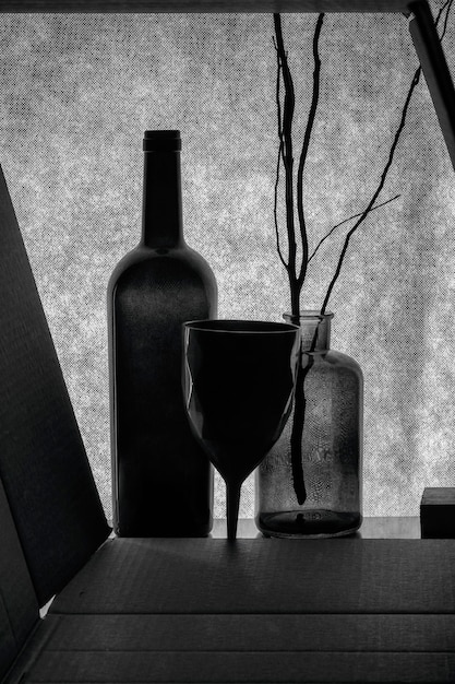 Black and white still life with bottle vase and glass