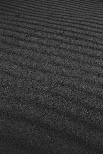 A black and white super texture and repetitive background of the sand of the beach with a great pattern