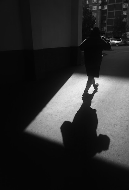 Black and white walking male with dramatic shadow background