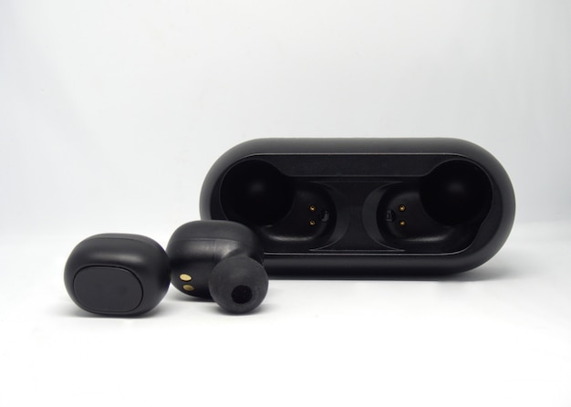 Black wireless headphones near charging case.