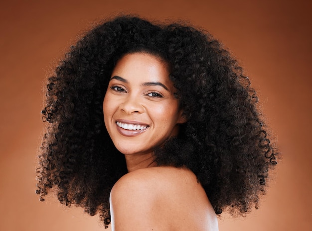 Black woman afro beauty and smile for skincare makeup or cosmetics against a studio background Portrait of African American female smiling with teeth in satisfaction for cosmetic facial treatment